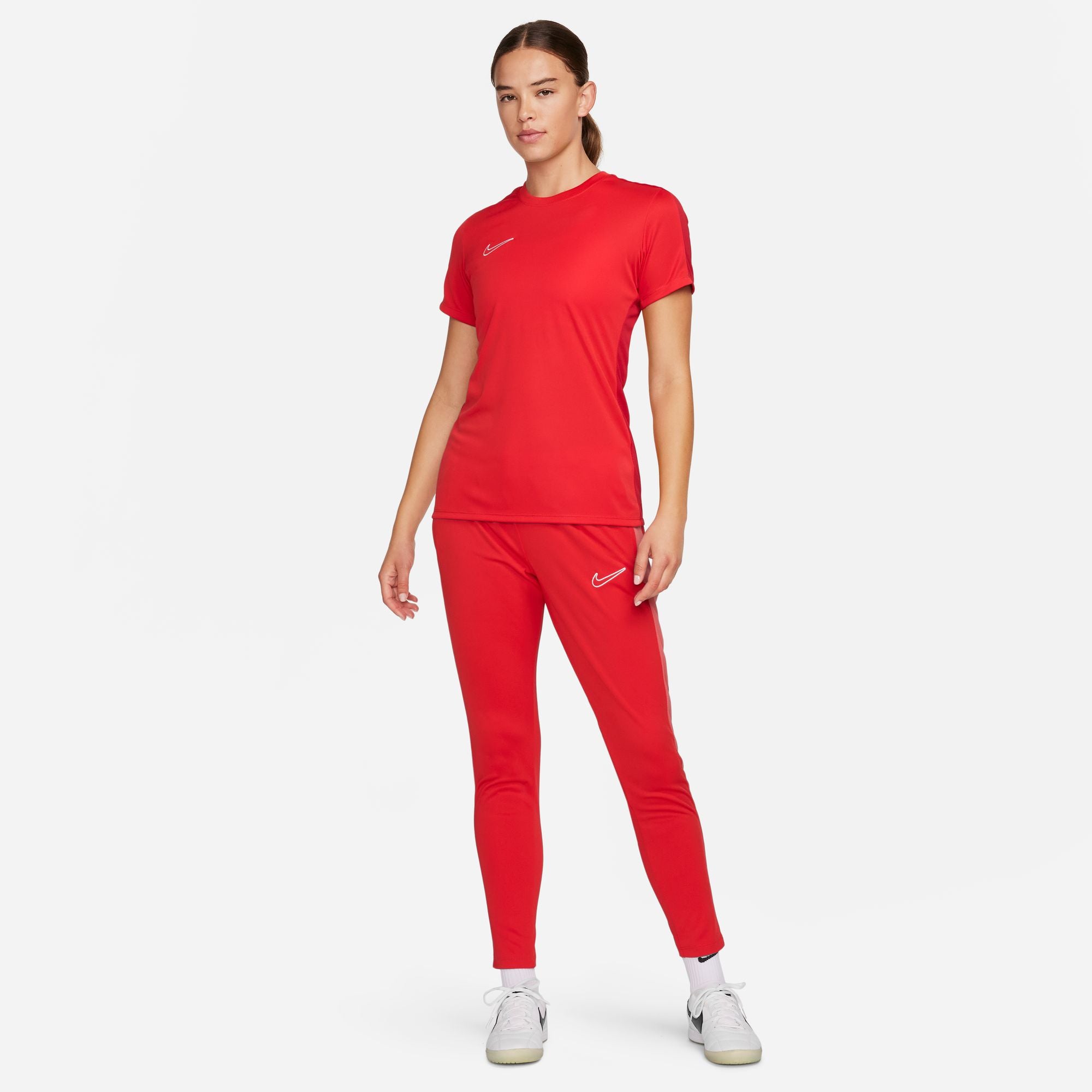 Nike Dri FIT Academy 23 Womens Short Sleeve Shirt in University Red/Gym Red with red nike tracksuit bottoms and white nike trainers