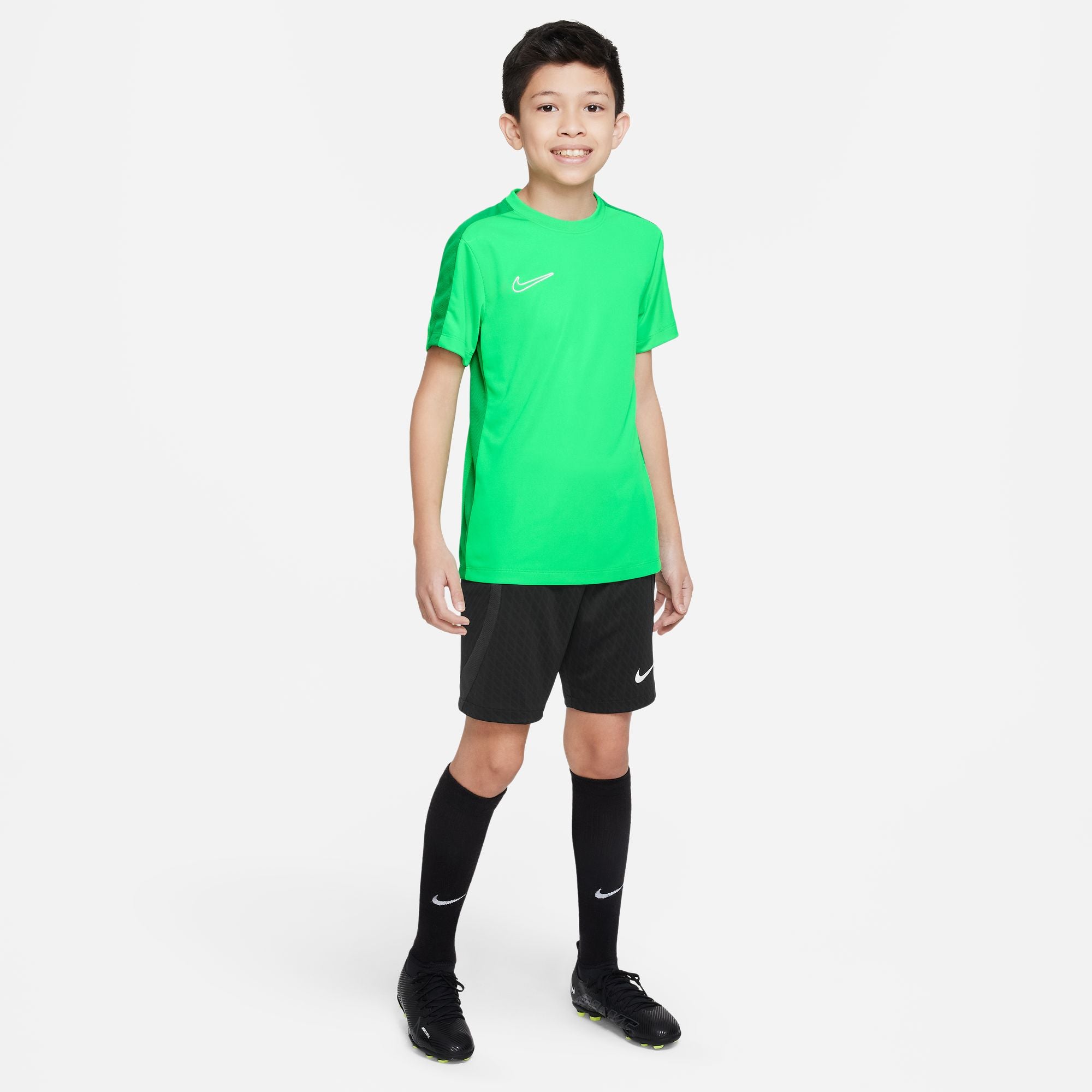 Nike Dri FIT Academy 23 Short Sleeve Shirt in bright green with black nike shorts, black nike socks and black football boots