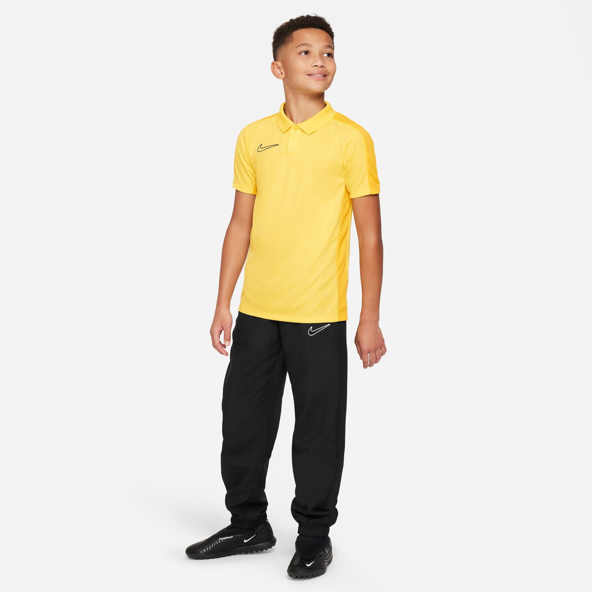 Nike Dri FIT Academy 23 Short Sleeve Polo in Tour Yellow/University Gold with black nike tracksuit bottoms and black nike trainers