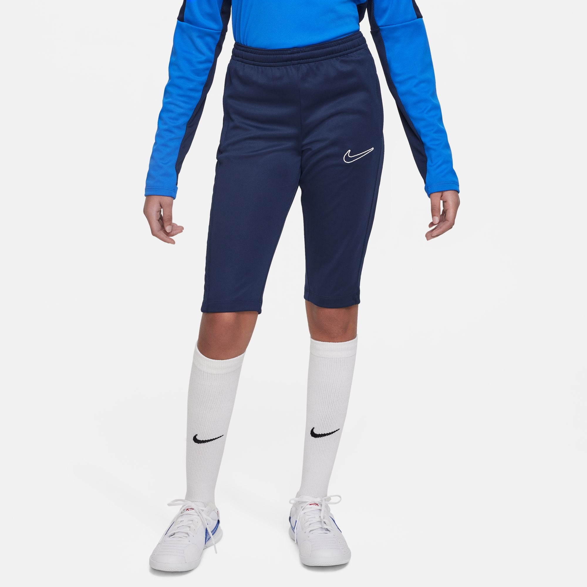 Nike Dri FIT Academy 23 3/4 Knit Pants in Obsidian with white nike socks and white nike trainers and royal blue nike track jacket